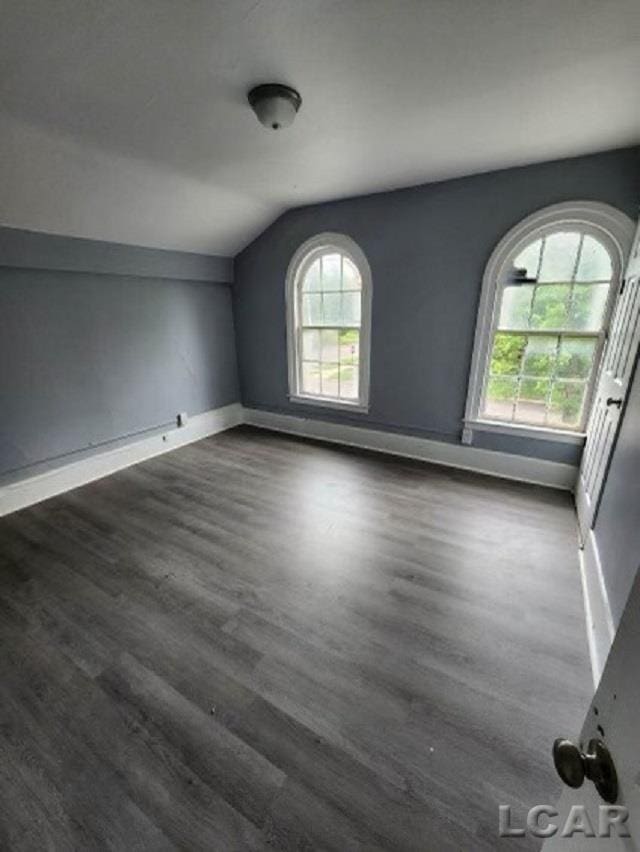 empty room featuring dark hardwood / wood-style floors and lofted ceiling