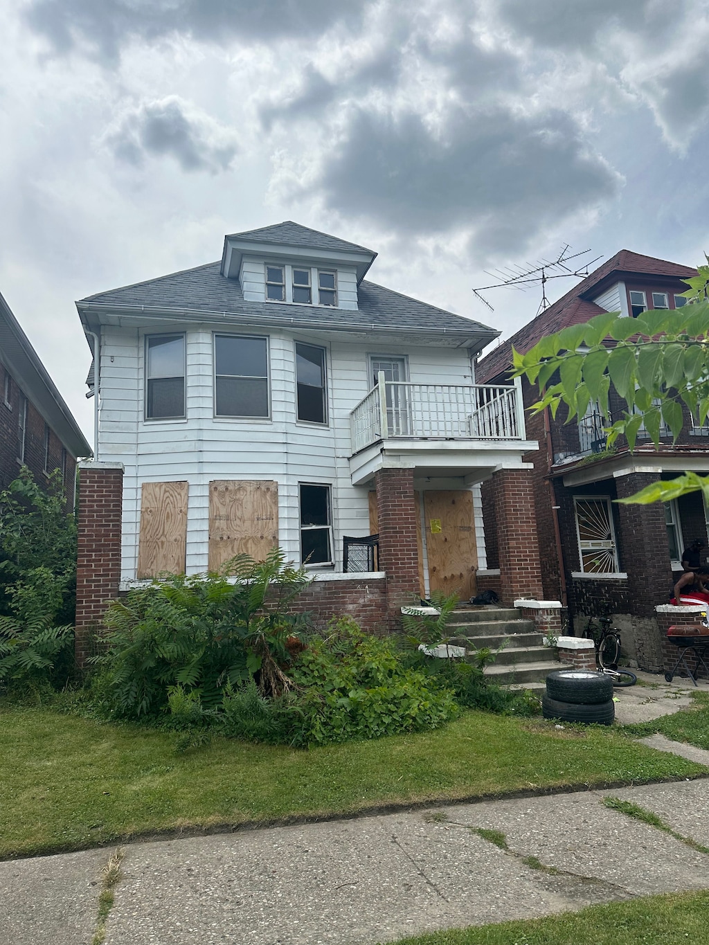 view of front of house featuring a balcony and a front lawn