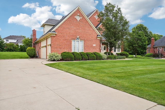 view of side of home featuring brick siding, an attached garage, a lawn, and driveway
