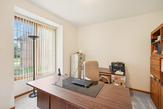 office space featuring baseboards and light carpet
