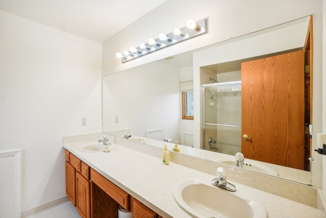 full bath featuring a sink, a shower with door, and toilet