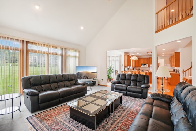 living area featuring recessed lighting, stairs, and high vaulted ceiling