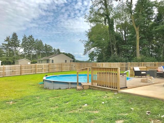 view of pool featuring a wooden deck and a lawn