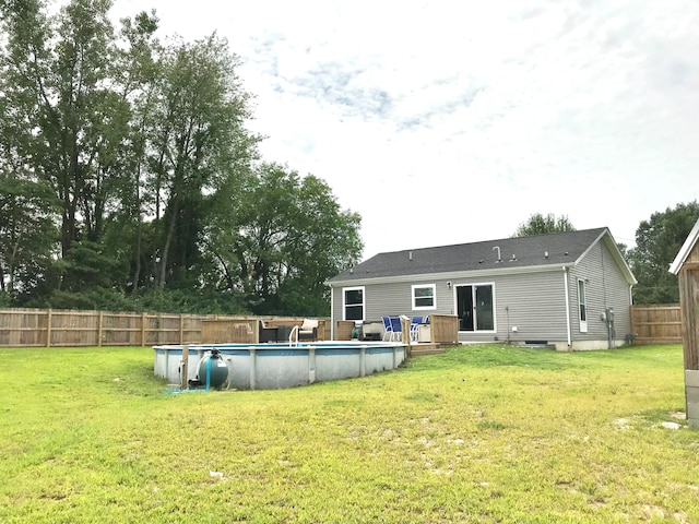 rear view of house with a lawn and a pool side deck