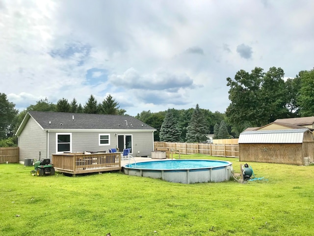 view of swimming pool with a storage shed, a yard, a wooden deck, and central AC