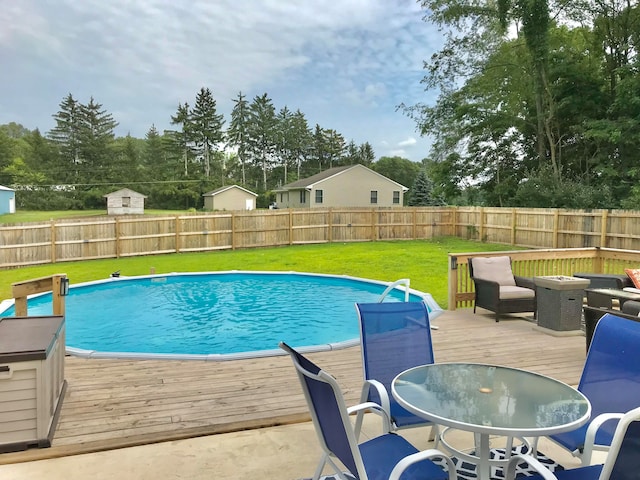 view of swimming pool with a deck and a lawn