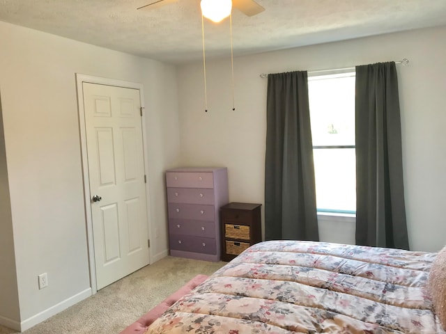 carpeted bedroom with a textured ceiling and ceiling fan