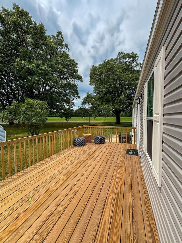 wooden deck featuring a lawn