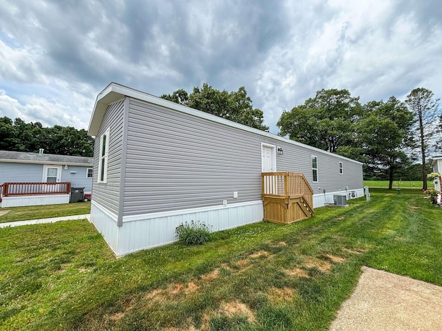 view of home's exterior with a lawn and central air condition unit