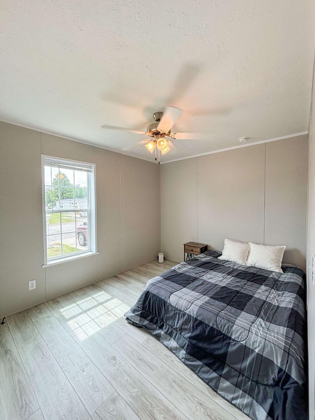 bedroom with wood-type flooring, a textured ceiling, and ceiling fan