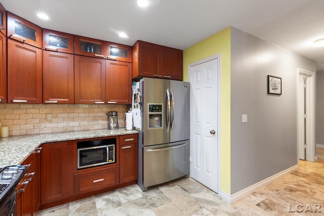 kitchen featuring backsplash, light stone countertops, and appliances with stainless steel finishes