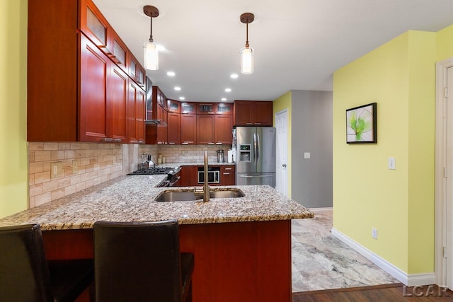 kitchen featuring kitchen peninsula, stainless steel refrigerator with ice dispenser, decorative light fixtures, and light hardwood / wood-style flooring