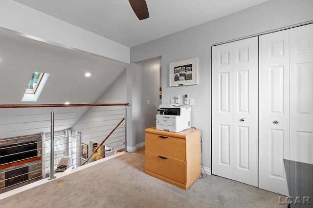 interior space featuring lofted ceiling with skylight and ceiling fan