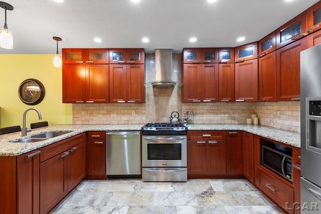 kitchen with wall chimney range hood, sink, decorative light fixtures, light stone counters, and stainless steel appliances