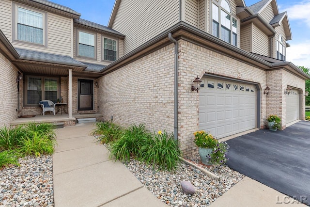 property entrance with covered porch and a garage