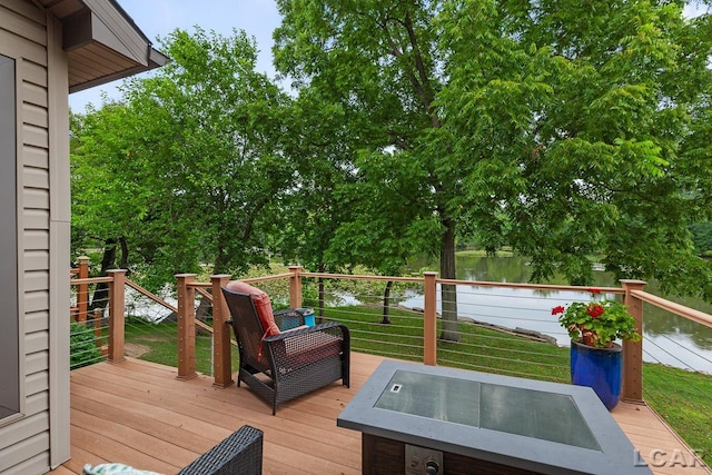 wooden terrace with a water view and a lawn