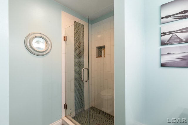 bathroom with toilet and an enclosed shower