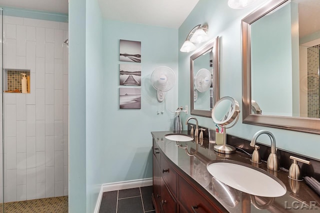 bathroom with tiled shower, vanity, and tile patterned floors