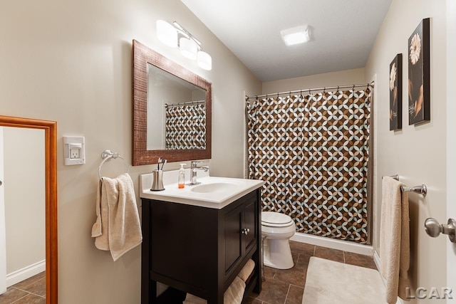 bathroom with tile patterned floors, vanity, toilet, and walk in shower