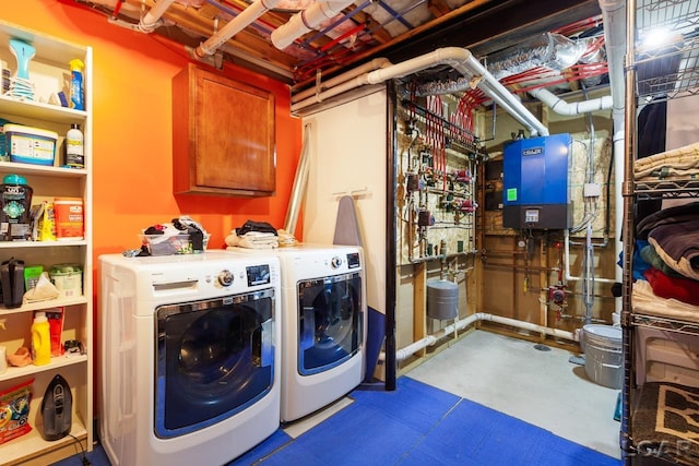 laundry room featuring cabinets, separate washer and dryer, and water heater