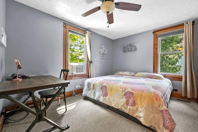 carpeted bedroom featuring a textured ceiling, ceiling fan, and cooling unit