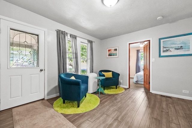 sitting room with wood-type flooring and a textured ceiling