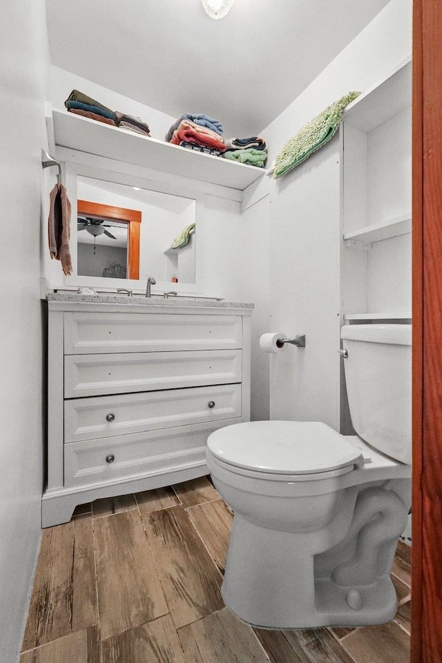 bathroom with toilet, vanity, and hardwood / wood-style flooring