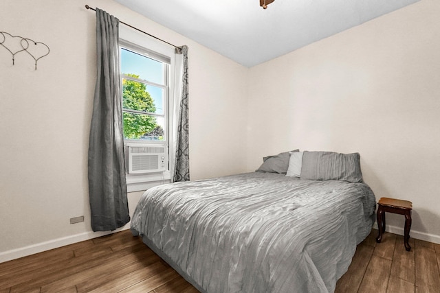 bedroom with cooling unit and wood-type flooring