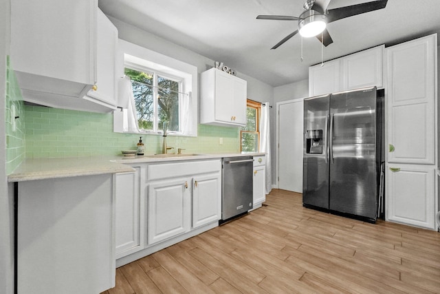 kitchen with sink, decorative backsplash, light hardwood / wood-style floors, white cabinetry, and stainless steel appliances