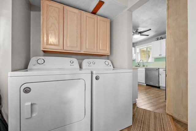 laundry area with ceiling fan, washing machine and dryer, sink, and light hardwood / wood-style flooring