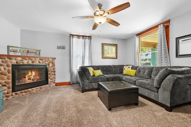 carpeted living room with ceiling fan and a fireplace