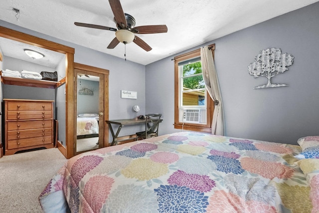 carpeted bedroom featuring ceiling fan and a textured ceiling