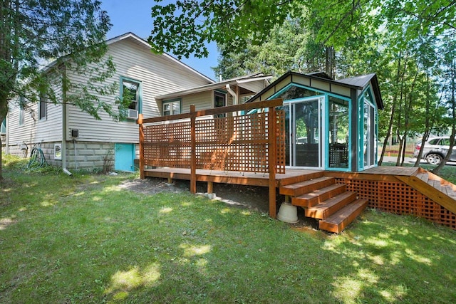 rear view of house with a sunroom, a deck, and a lawn