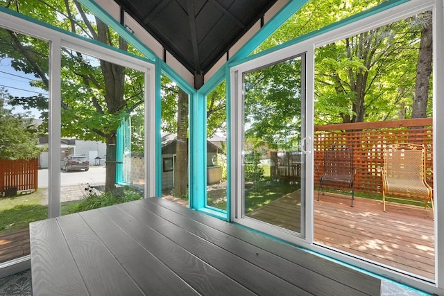 unfurnished sunroom featuring a healthy amount of sunlight and lofted ceiling