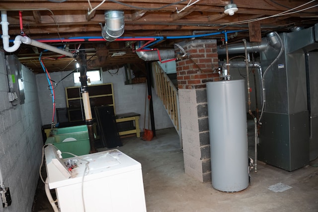 basement with washing machine and clothes dryer, heating unit, and water heater