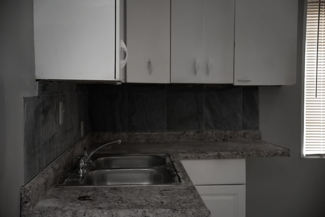 kitchen featuring white cabinets and sink