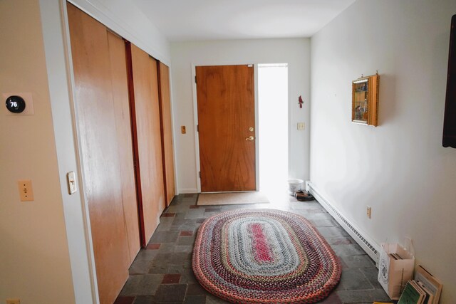 3447 200th Ave, Reed City, MI 49677 - entryway featuring stone tile floors, a baseboard heating unit, and baseboards