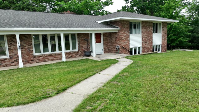 3447 200th Ave, Reed City, MI 49677 - split level home featuring a front lawn, roof with shingles, and brick siding