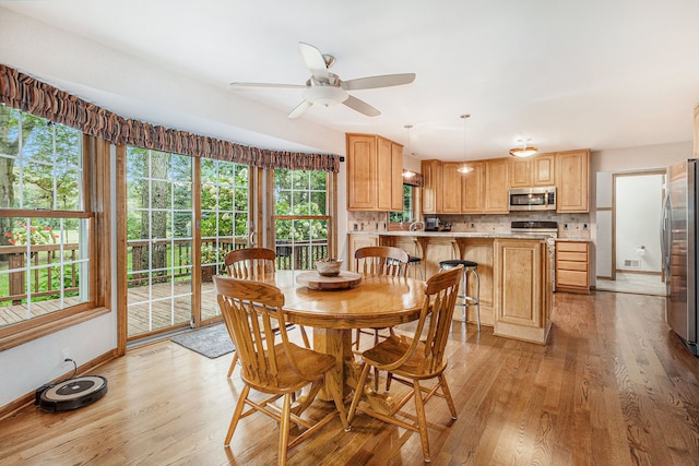 dining space featuring ceiling fan, light hardwood / wood-style flooring, and sink