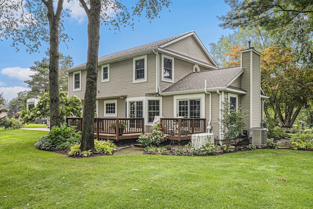 rear view of house with a lawn, central AC, and a deck