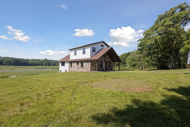 rear view of house with a lawn and a rural view