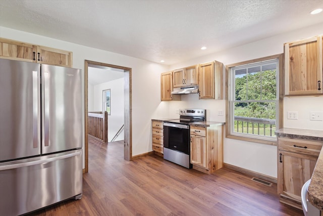 kitchen featuring appliances with stainless steel finishes, a textured ceiling, dark hardwood / wood-style floors, and light brown cabinetry