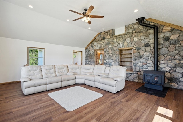 unfurnished living room with hardwood / wood-style floors, lofted ceiling, ceiling fan, and a wood stove