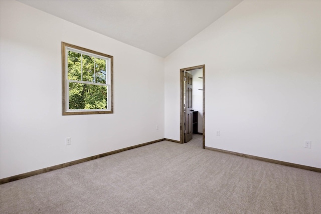 carpeted spare room with lofted ceiling