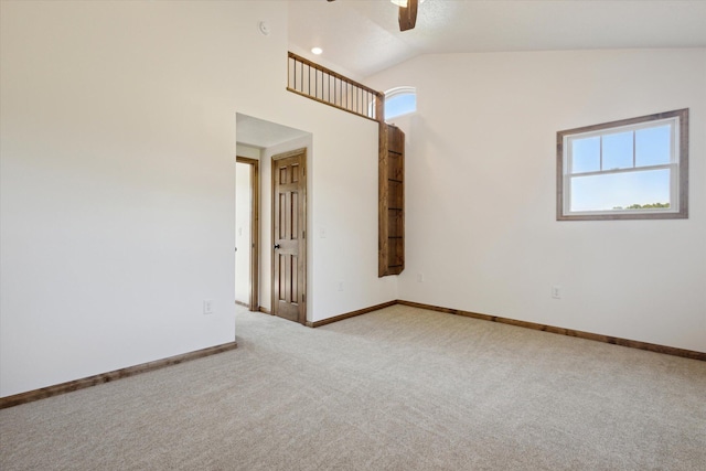 carpeted empty room featuring vaulted ceiling and ceiling fan