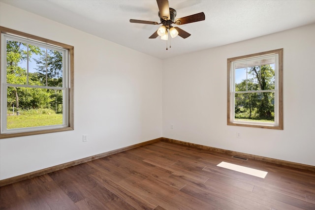 unfurnished room with ceiling fan and dark hardwood / wood-style flooring