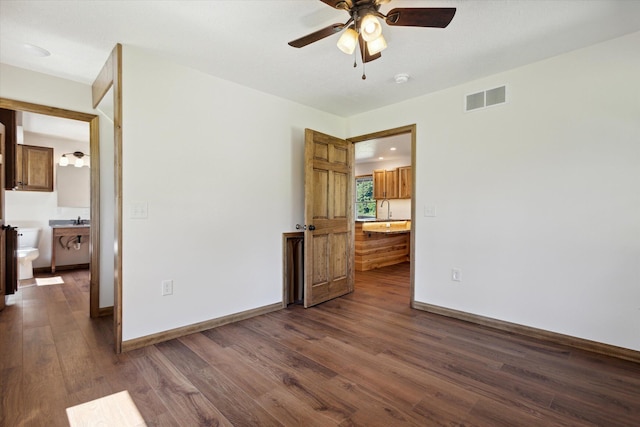 unfurnished room featuring dark hardwood / wood-style floors, ceiling fan, and sink