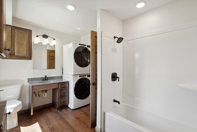 full bathroom featuring hardwood / wood-style floors, vanity, bathtub / shower combination, toilet, and stacked washing maching and dryer