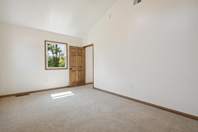 empty room featuring light carpet and high vaulted ceiling