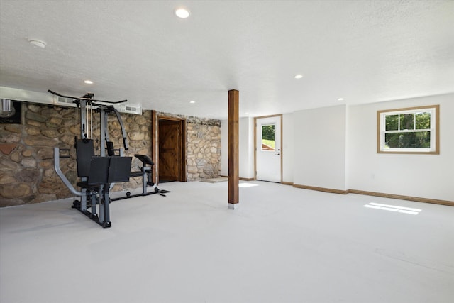 exercise room featuring a textured ceiling and light colored carpet